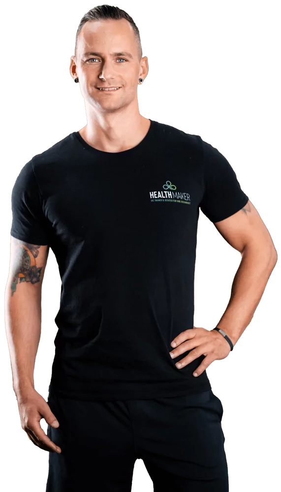Marco Neumann, Personal Trainer in Friedberg, steht in schwarzer Trainingskleidung mit Health Maker Logo und lächelt in die Kamera.