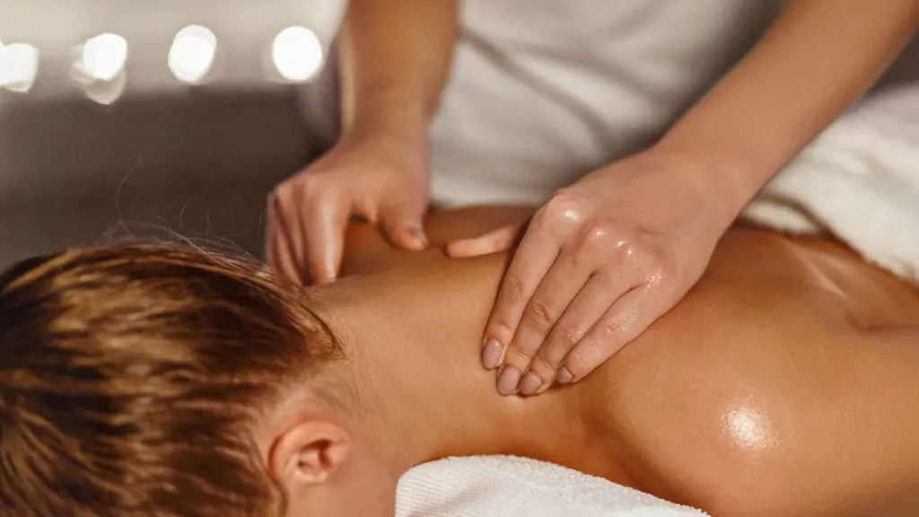 Therapeutin entspannt den Nacken einer Frau bei der Alpha Reset Massage in Augsburg