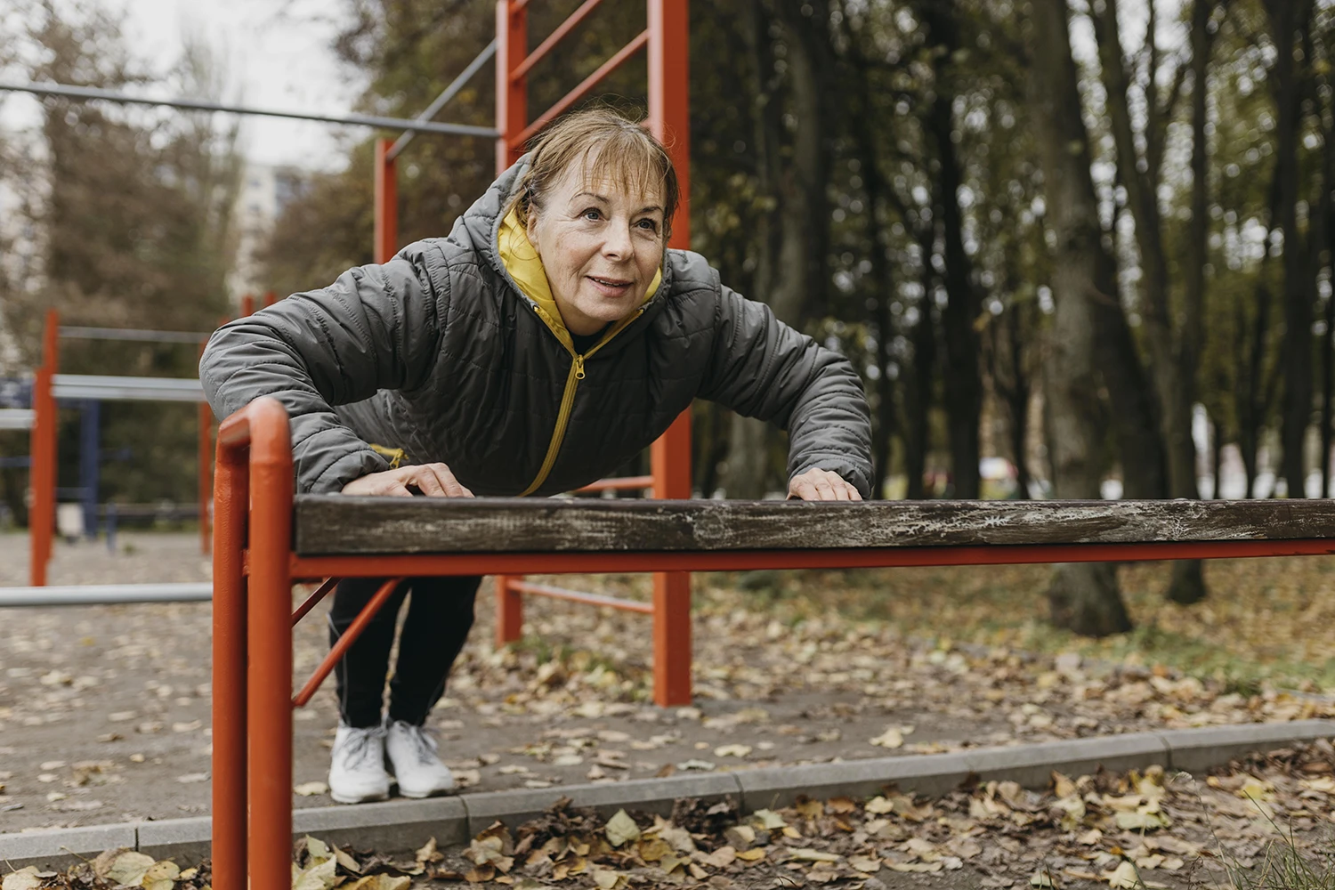 Frau führt Übungen an einer Parkbank aus zur Kräftigung der Muskulatur