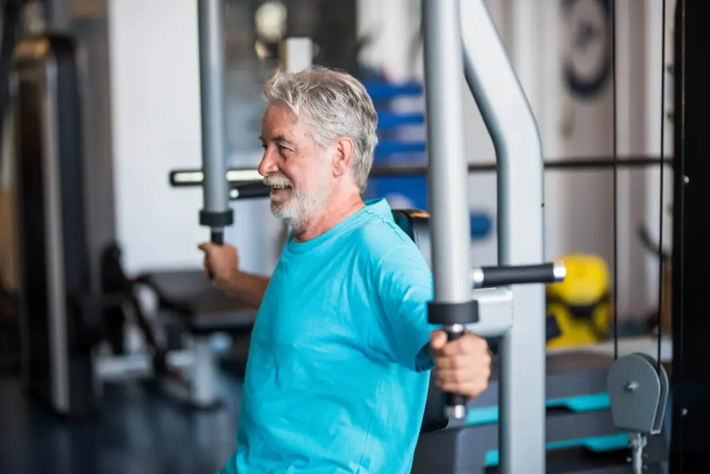Grauhaariger Mann an der Brustpresse beim gerätegestützten Krafttraining