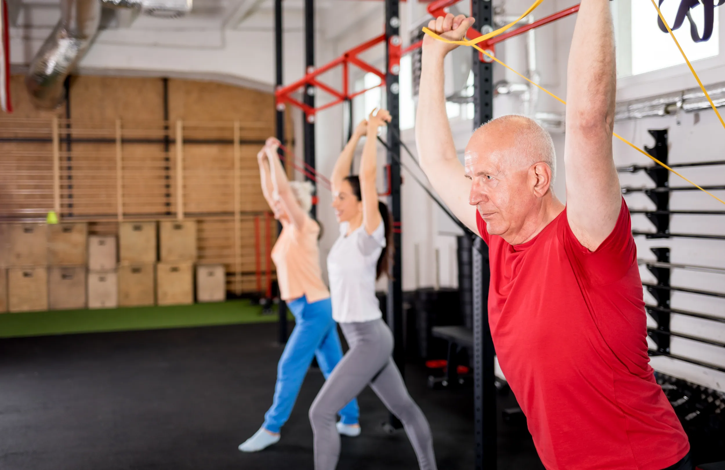 Frau trainiert mit rotem Widerstandsband in der Trainingsgruppe
