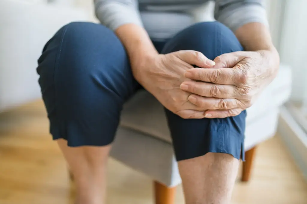 Alterserkrankungen vorbeugen 1 Frau hält sich ihr Knie und hat schmerzen