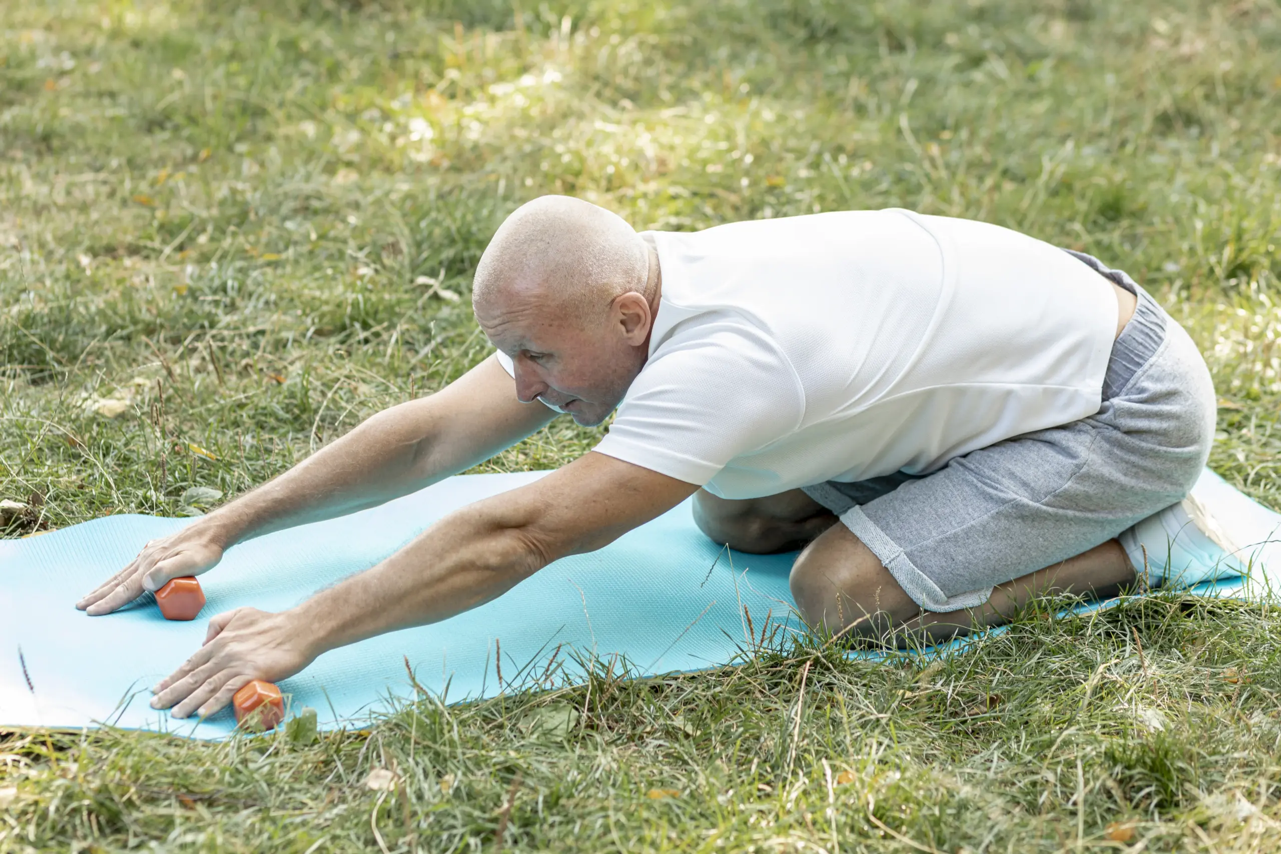 Seniorensport Augsburg 2 Älterer Mann dehnt sich auf der Yogamatte für mehr Beweglichkeit